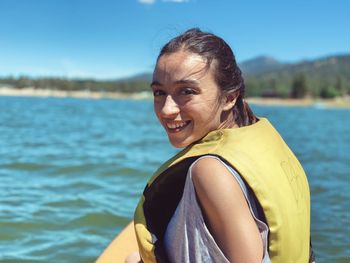 Portrait of smiling woman against lake