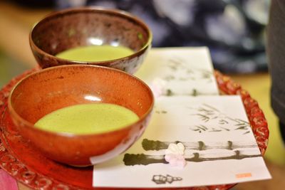 Close-up of japanese green tea in cup on plate