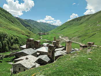 Scenic view of field and village against sky