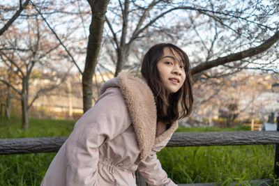 Portrait of smiling woman in park during winter