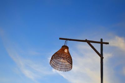 Low angle view of lighting equipment against blue sky