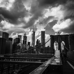 Low angle view of skyscrapers against cloudy sky