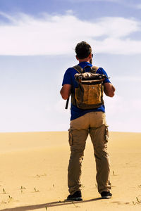 Rear view of man standing at beach