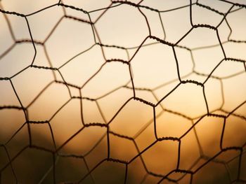 Full frame shot of soccer goal against sky during sunset