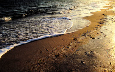 High angle view of waves rushing towards sea shore