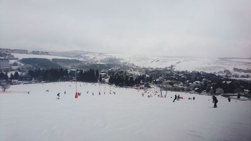 People on snowcapped mountain against sky