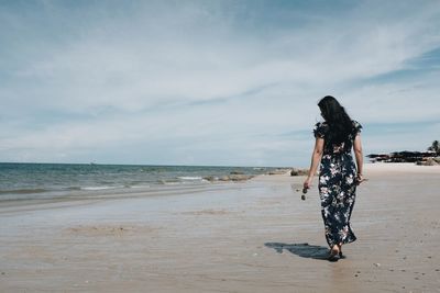 Boy on beach against sky