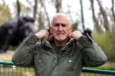 Portrait of expressive middle aged man posing in front of mammoth models in a public park