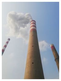 Low angle view of smoke stack against sky