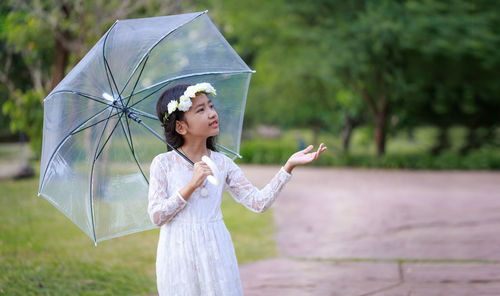 Woman holding umbrella while standing in rain