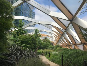 Low angle view of bridge amidst buildings against sky