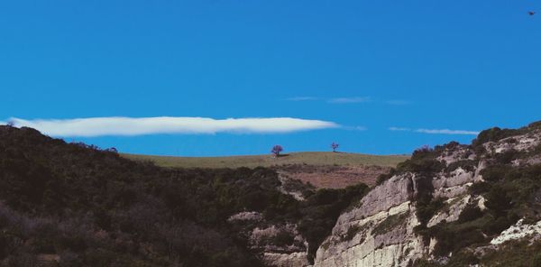 Scenic view of rocky mountains against blue sky