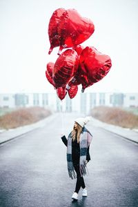 Woman with umbrella on road in city