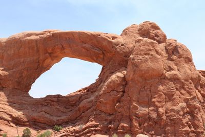 Low angle view of natural arch at arches national park against sky