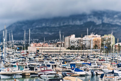 Boats moored in harbor against buildings in city