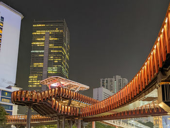 Low angle view of illuminated buildings against sky at night