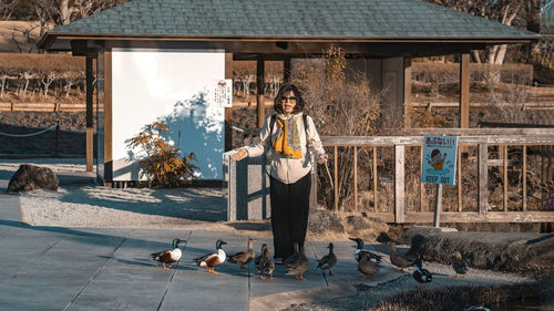 Rear view of woman standing against building