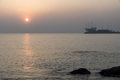 Sailboat sailing on sea against sky during sunset