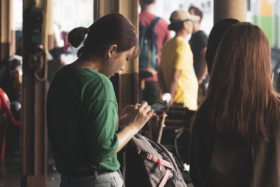 Side view of young woman using mobile phone