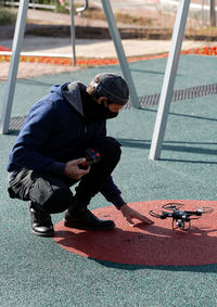 Full length of man flying drone outdoors