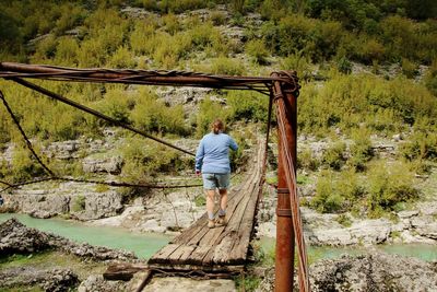 Rear view of woman standing on a footbridge 