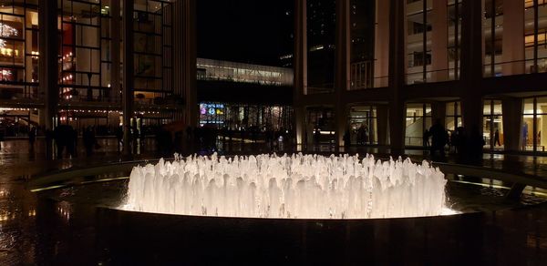 Fountain in illuminated building at night