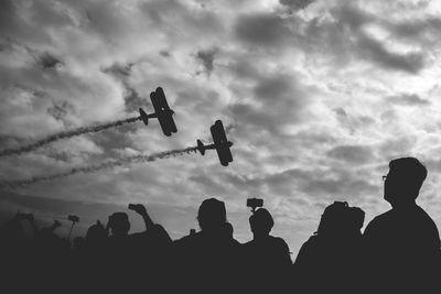 Low angle view of silhouette people against sky