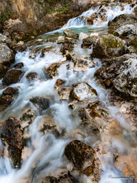 High angle view of stream flowing through rocks