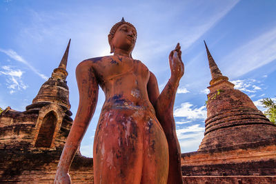 Low angle view of statue against temple against sky