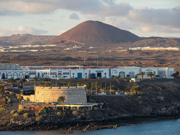 Buildings by sea against sky in city