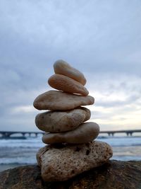 Stack of stones on beach against sky