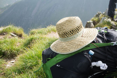 Close-up of straw hat on backpack at mountain