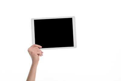 Close-up of hand holding camera against white background