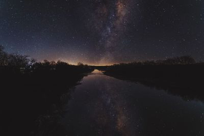 Scenic view of lake against sky at night