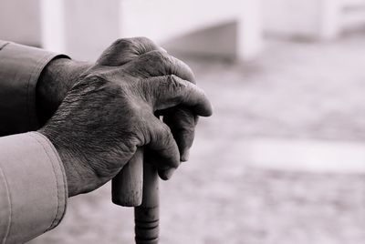 Cropped hands of senior man holding walking cane