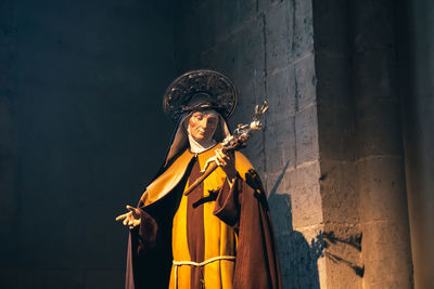 Statue of female saint holding flower in cathedral