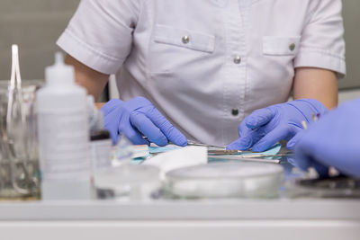 Midsection of nurse holding equipment