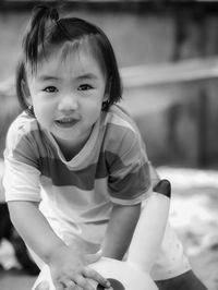 Portrait of cute girl crouching outdoors