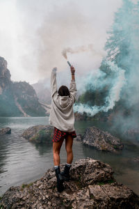 Full length of man standing on rocks against sky