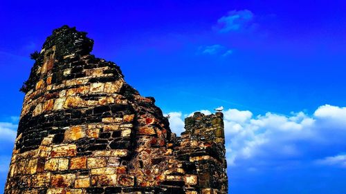 Low angle view of old building against blue sky