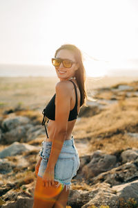 Young woman wearing sunglasses standing on beach