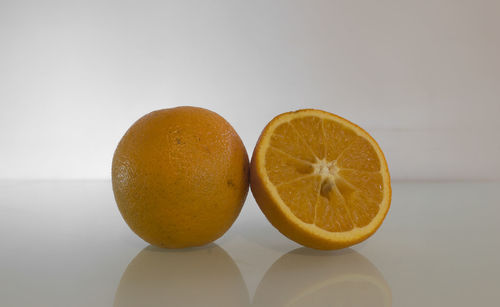 Close-up of oranges on table against white background