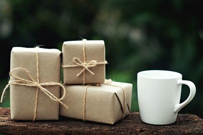 Close-up of gift boxes and coffee cup on wood