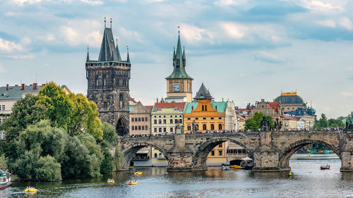 Arch bridge over river against buildings in city