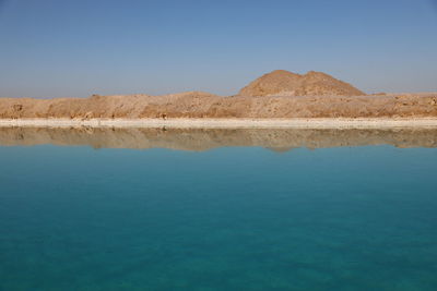 Scenic view of lake against clear blue sky