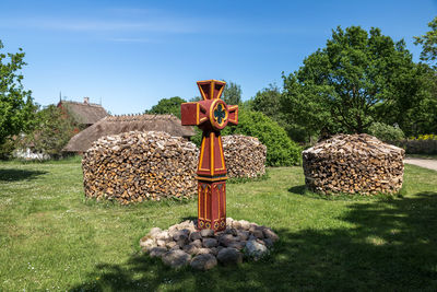 Stack of logs on field against sky