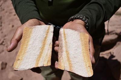 Man holding desert rock cut in half 