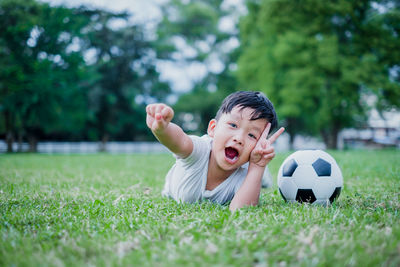 Boy playing soccer ball on grass