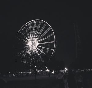 Low angle view of illuminated ferris wheel against sky at night