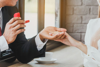 Close-up of couple with wedding ring at table